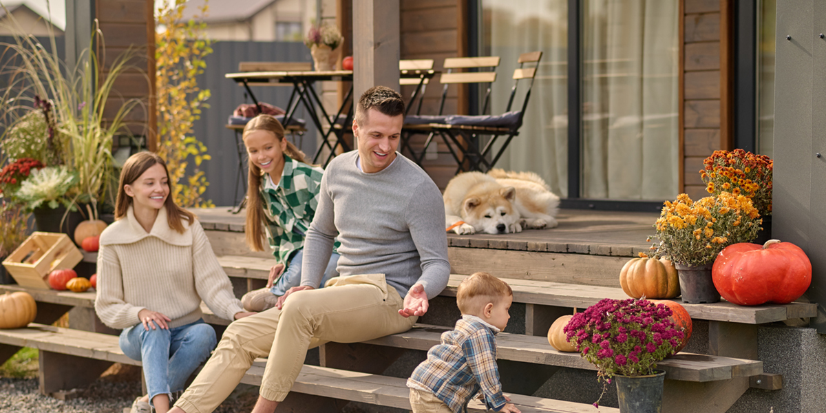 A family on the steps of the primary residence they will sell, hoping to avoid capital gains tax