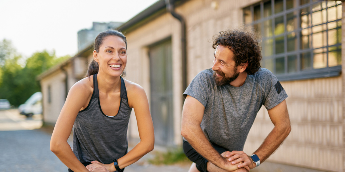 Couple stretching after a run talking about insurance reviews