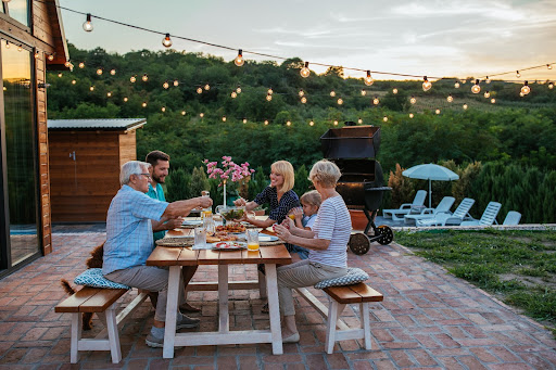 Older parents share a home-cooked meal outside with their child and family. They discuss estate planning essentials of State and Federal Tax Laws.