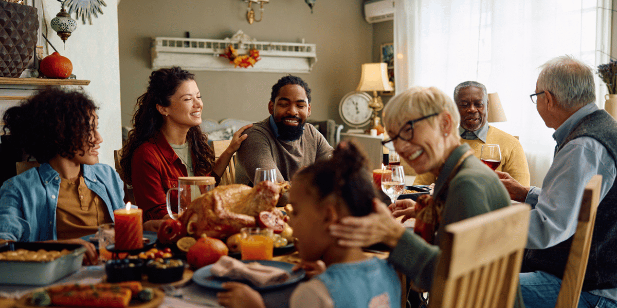 family happy at dinner table during the holidays because their sachetta advisor helped them plan for year end tax and investment strategies