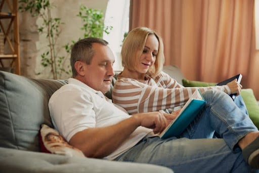 Middle aged couple sitting on sofa in the living room.