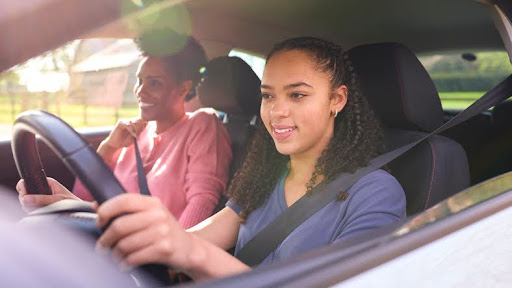 Mom and teen daughter driving lesson. Financial literacy for teenagers and young adults.