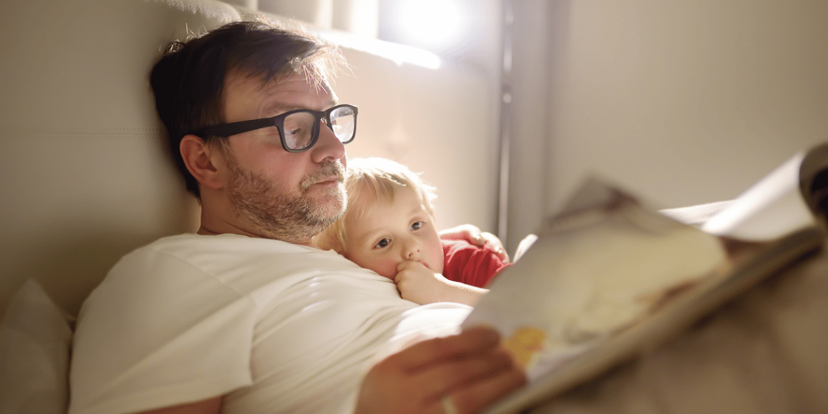 Father reading bedtime stories to child. How tech trends impact investment strategies.