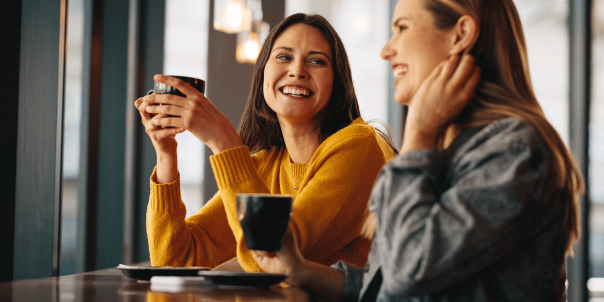 two female friends having coffee discussing how they found their trusted wealth management advisor