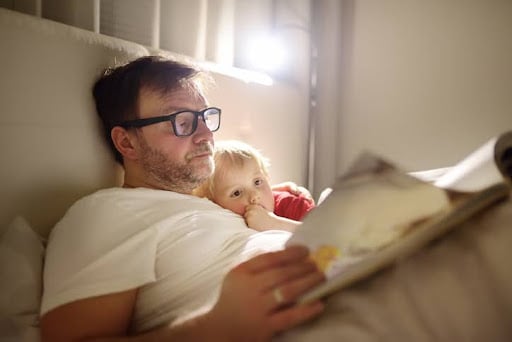 Father reading bedtime stories to child. How tech trends impact investment strategies.